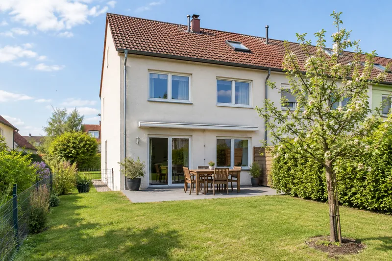 Reihenendhaus mit Terrasse, Rasen und jungem Apfelbaum